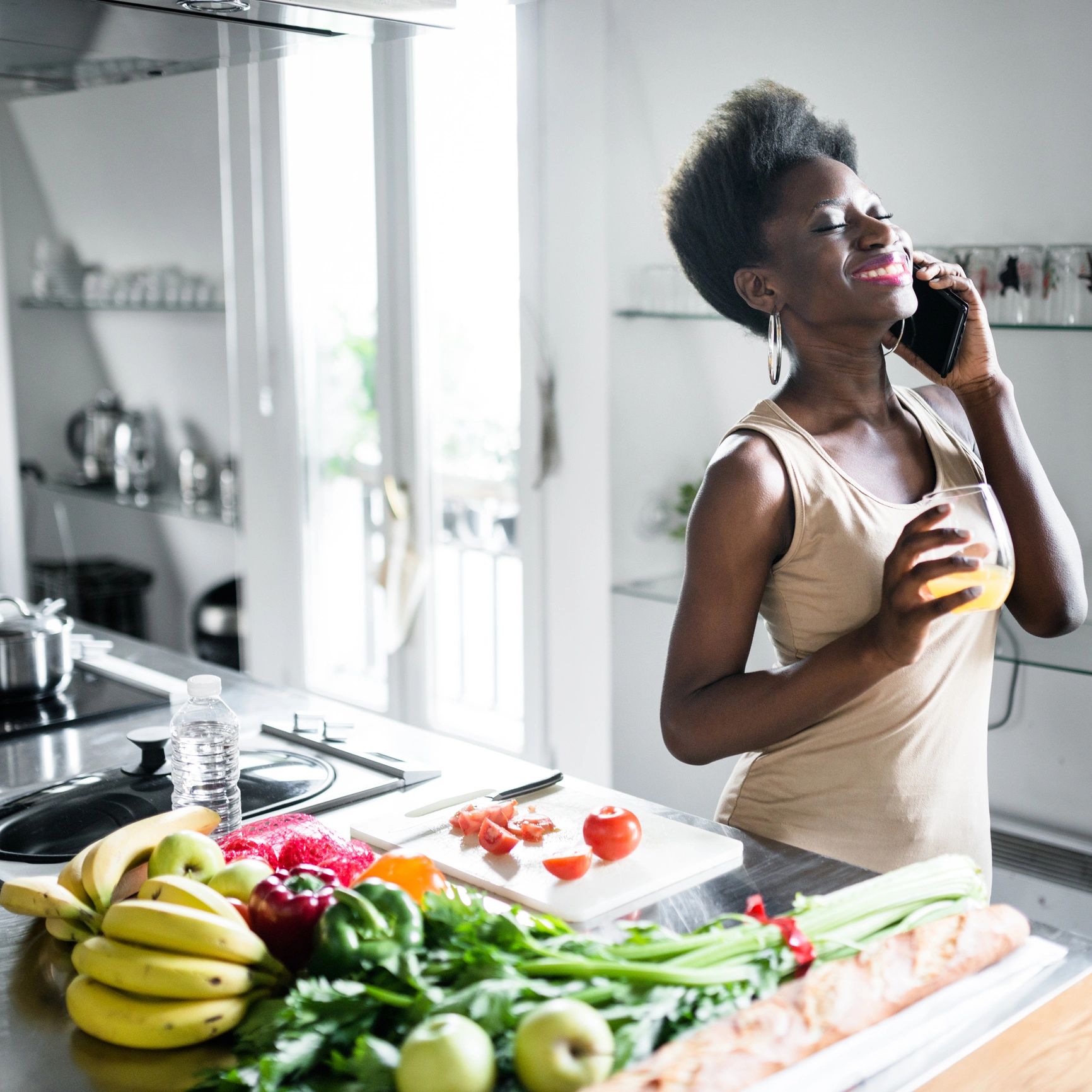 Happy homeowner speaking on the phone in kitchen